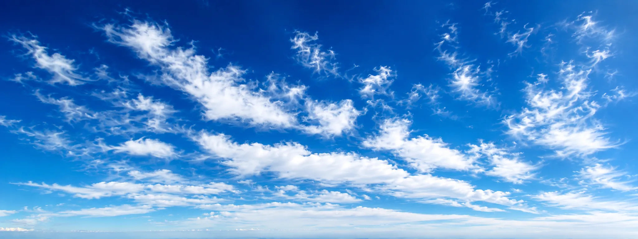 Blue sky with wispy white clouds stretching across a bright horizon | Polar Philippines