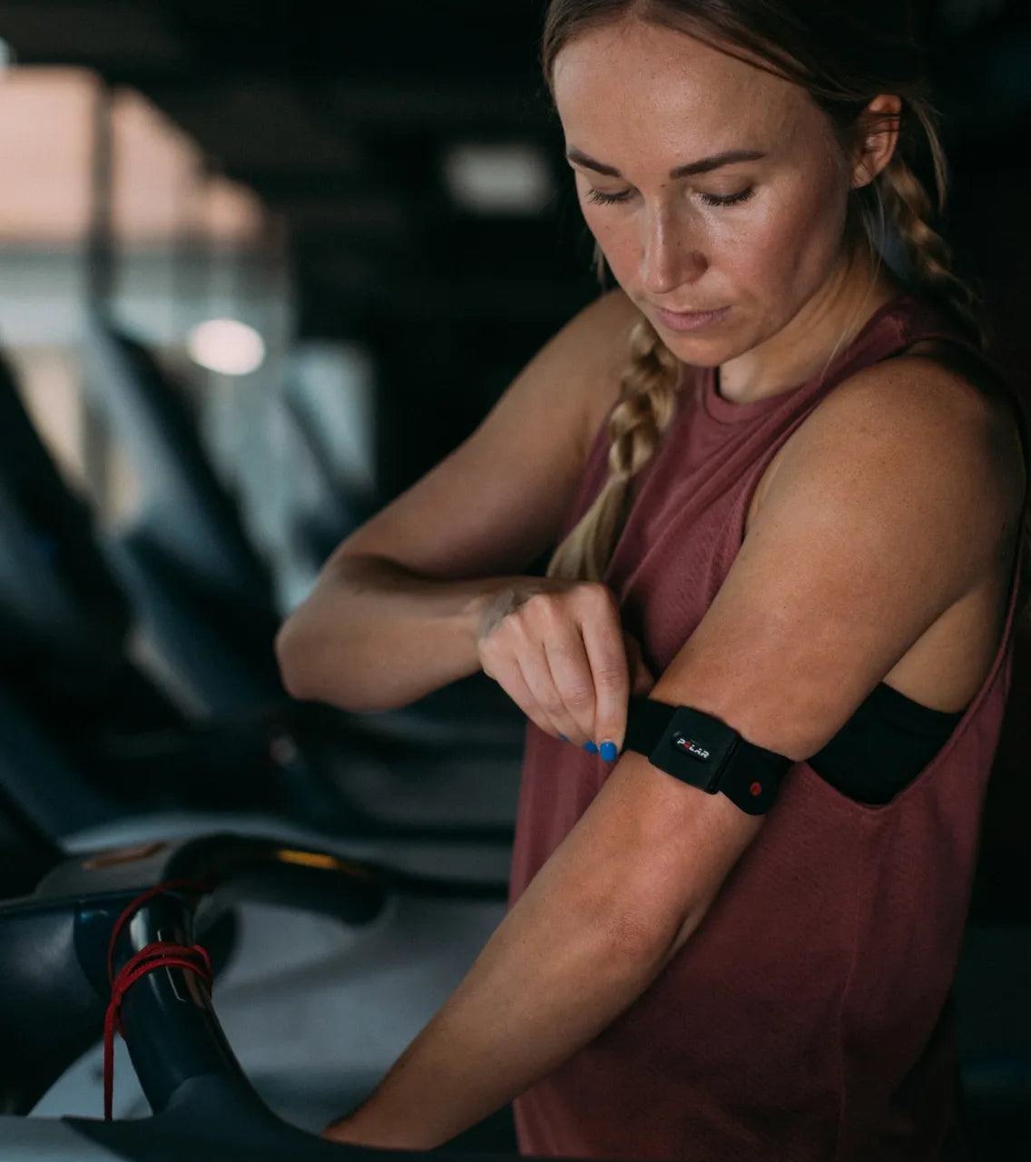 Close up of a female athlete placing a compact tracking sensor on her upper arm | Polar Philippines
