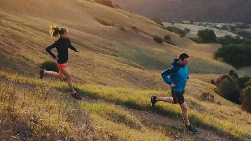 Two runners on a hillside trail during golden hour in lightweight performance apparel | Polar Philippines