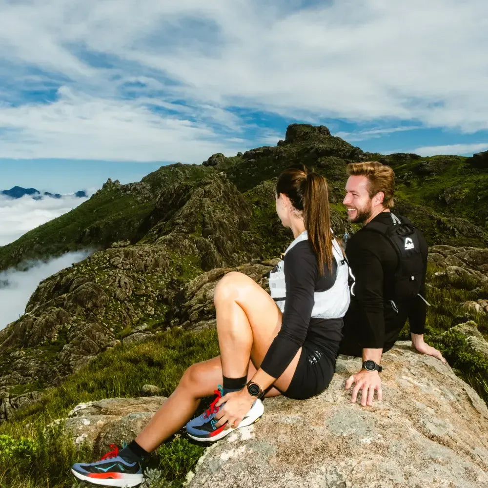 Two hikers wearing smart watches sitting on a rocky mountain summit | Polar Philippines