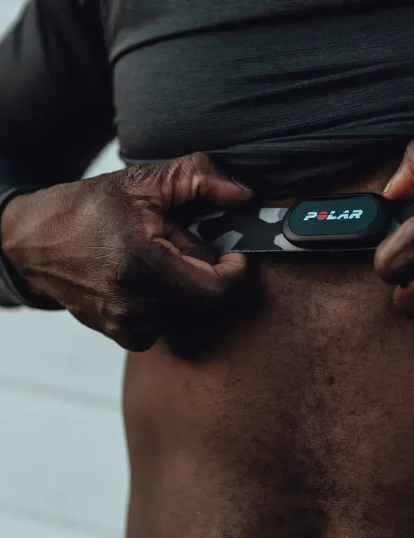 Athlete adjusting a camo patterned chest strap heart rate monitor | Polar Philippines